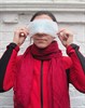 Photograph of a woman with a (clean) sanitary towel held over her eyes