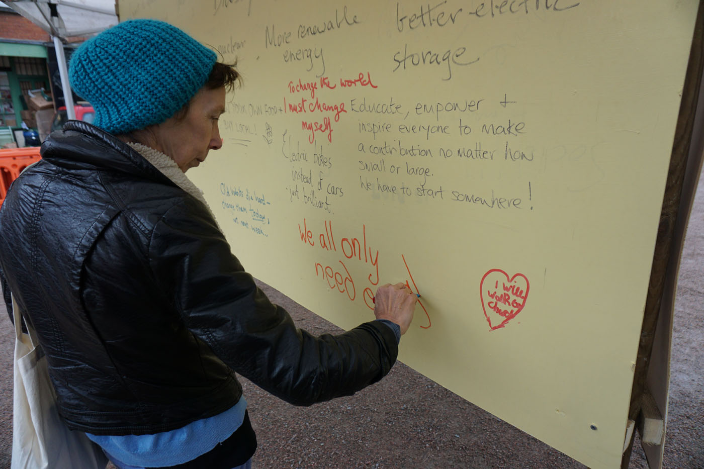 Photograph of a man writing on the graffiti board