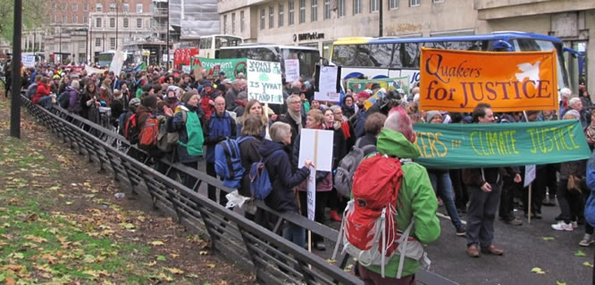 Photograph of crowds of people in Park Lane led by climate justice banners